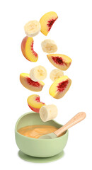 Baby food. Banana and peach slices falling into bowl of puree on white background