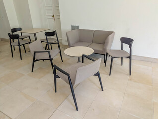 Modern minimalist dining area with gray upholstered chairs and round wooden table in bright interior
