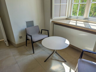 Fototapeta premium Modern office meeting space with round white table and contemporary chairs in well lit interior
