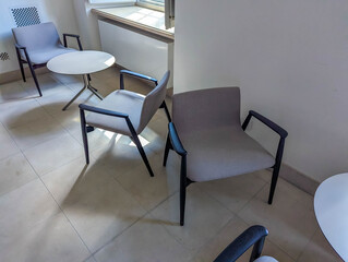 Contemporary office chairs with metal frames positioned on polished concrete floor in modern workspace environment