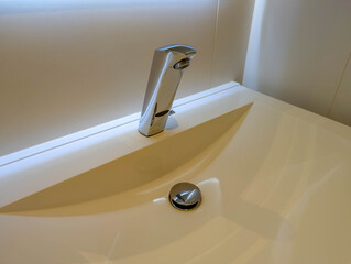 Close-up detail of modern bathtub spout with contemporary design and polished finish in upscale bathroom