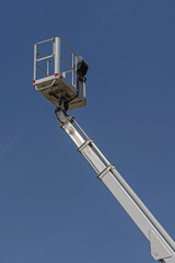 Obraz premium Telescopic Boom Crane Hydraulic Platform Elevated Work Over Blue Sky