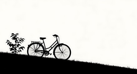 Obraz premium Minimalist bicycle silhouette on a grassy hill against a bright, spacious backdrop for creative projects.