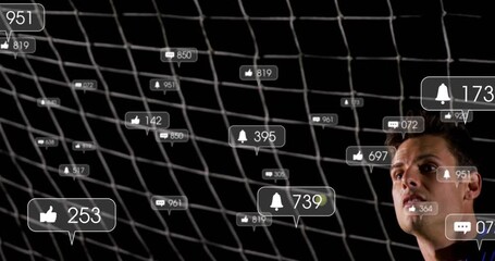 Frame spawning floating social media icons around goalkeeper diving, securing soccer ball at night - Powered by Adobe
