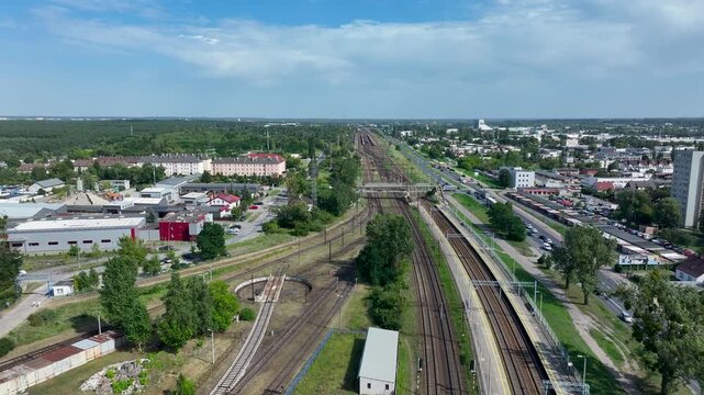 Aerial Bydgoszcz Poland along railroad tracks. Public and mass transportation in central eastern Europe. Commercial and passenger, economic. Forest, urban, industrial. Electric powered engines.