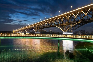 Fototapeta premium Nanjing skyline illuminated during warm summer evening with stunning sunset reflections over the Yangtze River