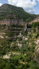 A mountain with a waterfall and trees