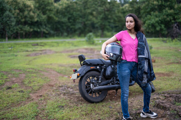 Naklejka premium Strong independent Indian woman biker: beautiful girl, stylish rider, motorcycle adventure, elegant jacket, confident posture, powerful machine, free spirit, road journey, fearless attitude.