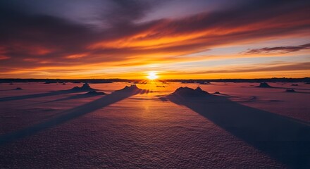 Stunning sunset landscape photography showcasing an Icefield Vista with long shadows cast across a snow-covered plain, featuring warm orange and purple hues.
