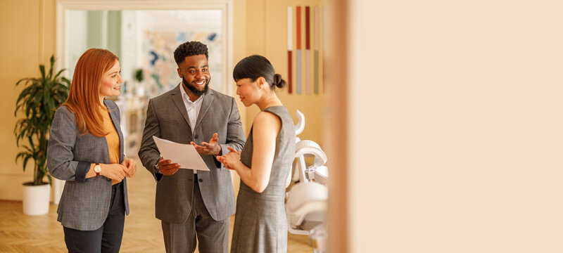 Male professional holding documents and brainstorming innovative ideas with female teammates in office