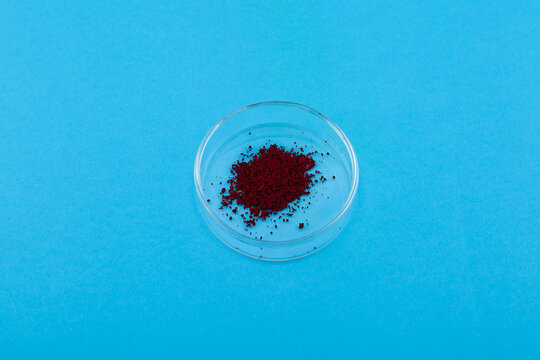 Azorubine or carmoisine powder in Petri dish. E122. Red azo dye. Controversial additive. Food coloring causes food intolerance and ADHD-like behavior in children