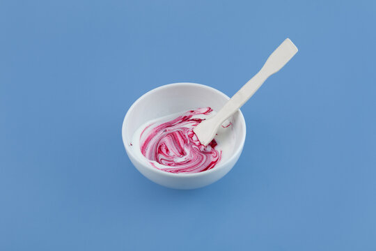 Red fat-soluble dye dissolves in buttercream. Azorubine or Carmoisine powder mixed with ceramic spatula in cream base. Food additive E122. Red dye, causes hyperactivity in children