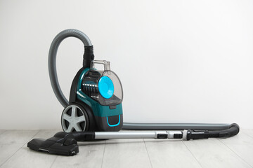 Fototapeta premium One vacuum cleaner on floor near white wall