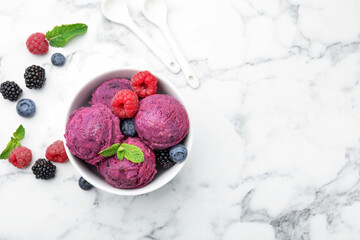 Delicious sorbet with fresh berries and mint in bowl on white marble table, flat lay. Space for text