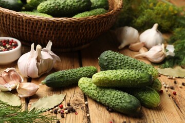 Making pickles. Fresh cucumbers and other ingredients on wooden table, closeup