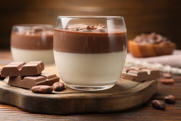 Delicious panna cotta with chocolate and cocoa beans on wooden table, closeup