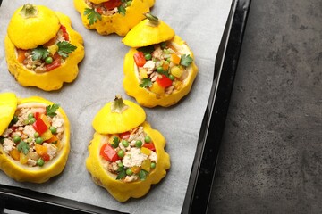 Tasty stuffed pattypan squashes on dark textured table, top view