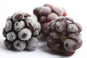 Frozen blackberries on white background, macro view