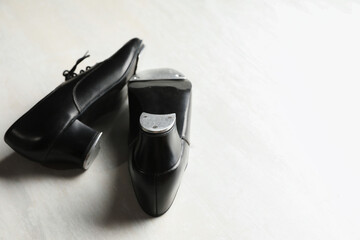 Pair of shoes for tap dance on white wooden floor, closeup. Space for text