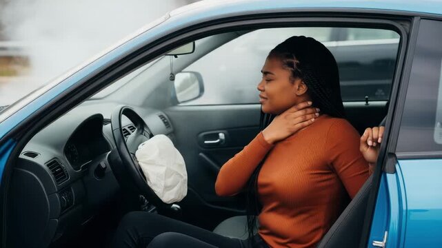 A distressed woman clutches her neck in pain after her cars airbag deployed during a crash