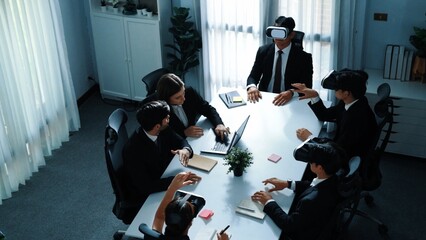 Top view of manager working on laptop and sending data analysis to business people by using VR glass headset while diverse team moving gesture while working together to planning idea. Directorate.