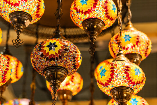 Colorful mosaic lanterns hanging from a decorative ceiling, creating a warm and inviting atmosphere