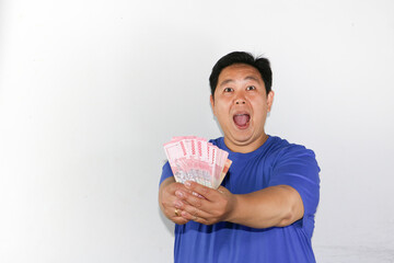 Portrait asian guy holding money on his hand, indonesian rupiah, bank note