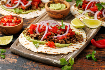 Tasty Beef Tacos with guacamole, tomato, onion and sauce. Tortilla Fast Food.