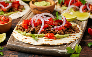 Tasty Beef Tacos with guacamole, tomato, onion and sauce. Tortilla Fast Food.