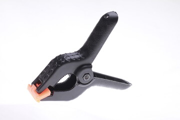 Obraz premium Black plastic spring clamp isolated on white background.