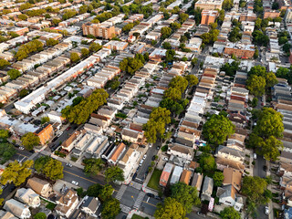 Aerial view of a dense residential neighborhood with rows of houses and tree-lined streets, suggesting an urban or suburban area.