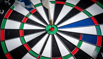 Dart hitting bullseye on dartboard.