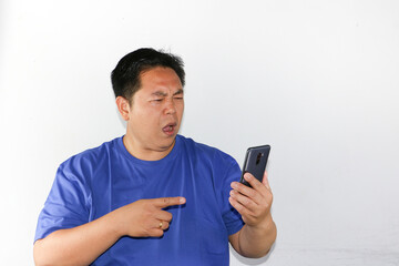 Portrait of young asian guy with mobile phone on his hand, modern lifestyle and online concept