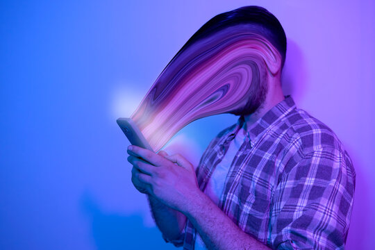 Smartphone and social network addiction concept. Face absorbed by use of smartphone