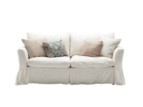 Comfortable white loveseat with a wrinkled slipcover and assorted textured and floral pillows.