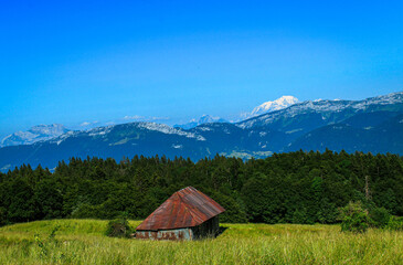 Chalet face aux Alpes sous un ciel bleu