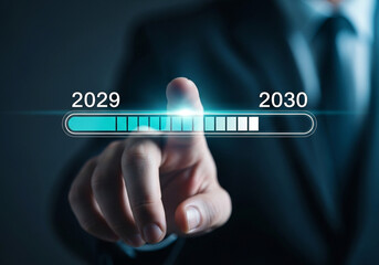 Photo of businessman pressing virtual progress bar representing the transition from 2029 to 2030 symbolizing future business development