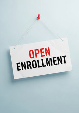 Photo of a sign on a blue wall announces the open enrollment period for employee health insurance benefits