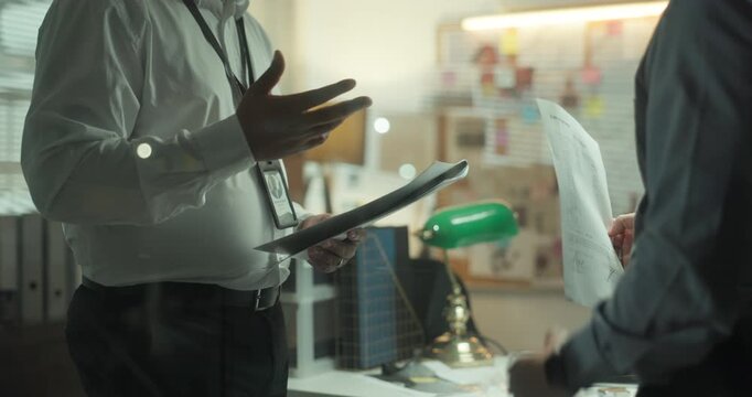 Paperwork, hands and detectives in office with meeting for solving case in collaboration. Documents, talking and male private investigators with discussion for briefing on investigation in workplace.