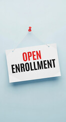 Photo of a white sign hanging on a blue wall announces the open enrollment period for health insurance benefits