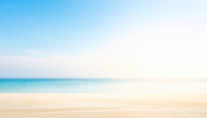 Fototapeta premium Blurred Beach Scene with Sandy Foreground and Blue Ocean Meeting Clear Sky Horizon