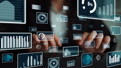A focused business analyst engages with data visualization tools while working on performance metrics and insights in a contemporary office environment. Xenic
