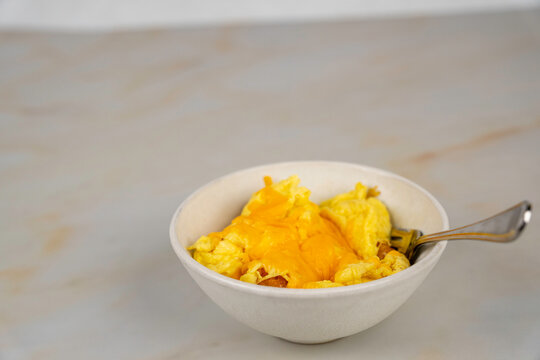 Breakfast bowl with eggs, cheese and hashbrown rounds 