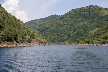 Boat tour through the Sil Canyon in Ribeira Sacra, Galicia, Spain, departing from Embarcadoiro da Ponte do Sil, Monforte de Lemos. Scenic river and vineyards.