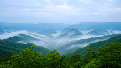 Naklejka premium Verdant mountain peaks shrouded in ethereal mist under a soft blue sky mountains valleys