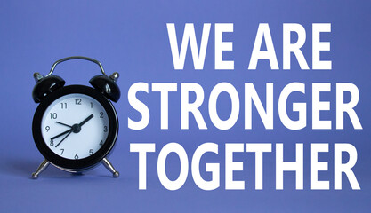 We are stronger together symbol. Beautiful purple background with alarm clock with words We are stronger together. Business and We are stronger together concept. Copy space.
