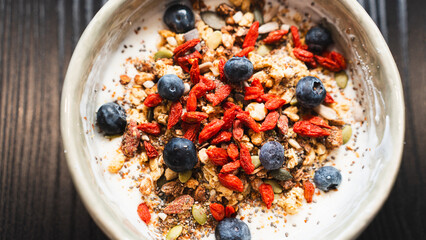 Nutrient-packed yogurt bowl with crunchy granola, mixed seeds and fresh blueberries. Perfect healthy breakfast for food blogs and lifestyle content