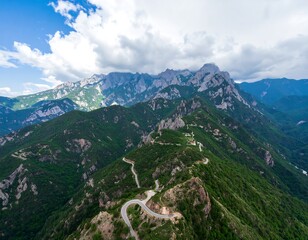 Naklejka premium Mountain road winding through lush green valleys