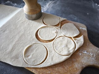 The process of making homemade pastries and dishes. Preparation of round shapes using a cut-out mold. For donuts, biscuits, ravioli, dumplings and other dough dishes