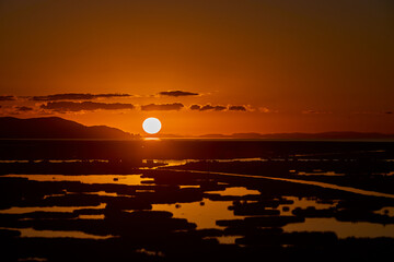 First light breaks over Lake Titicaca, painting the waters and Andes in hues of gold and rose — a serene awakening at the world’s highest navigable lake. Puno Peru.